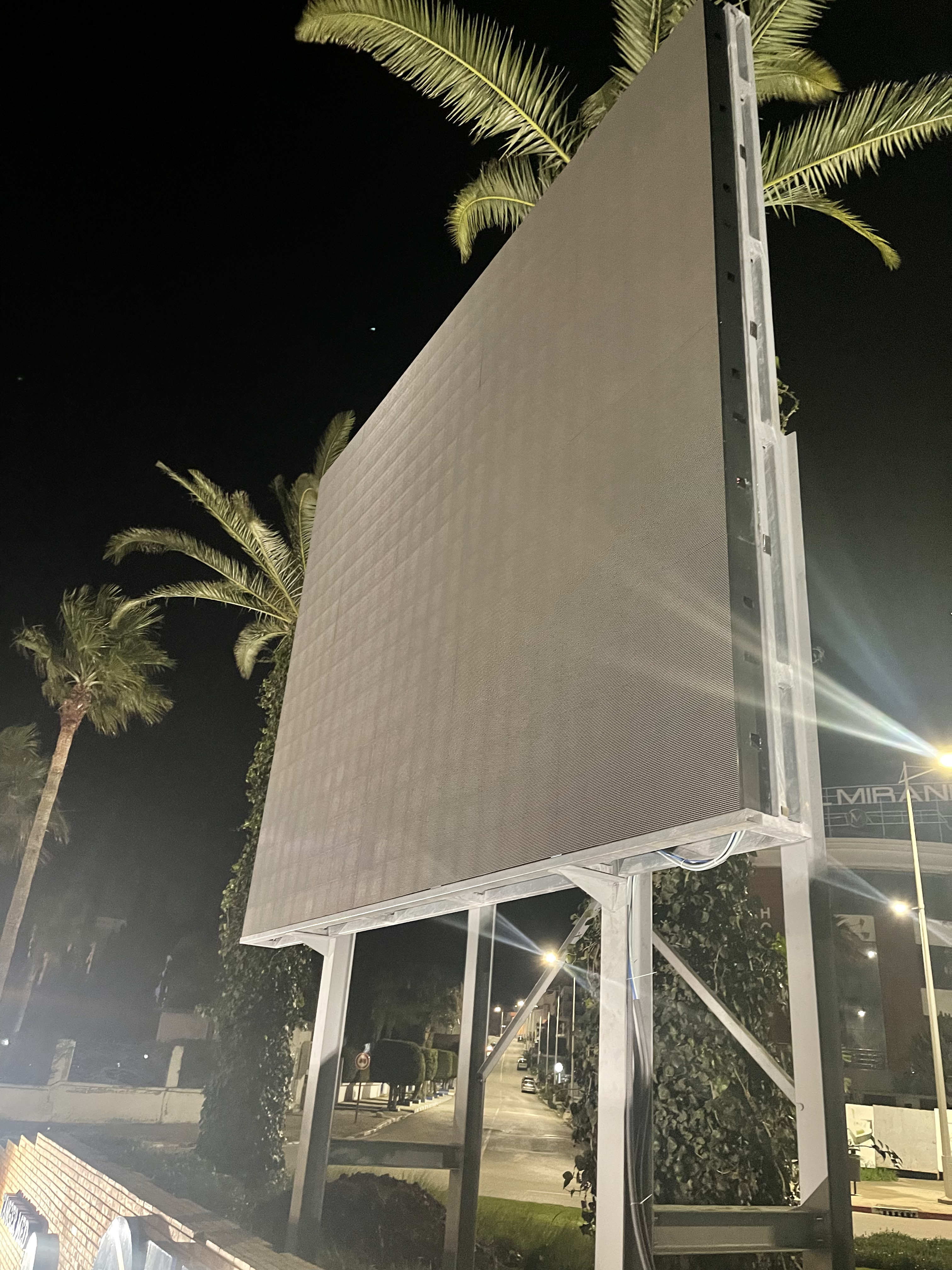 Écran LED double face installé de nuit dans un espace paysager
